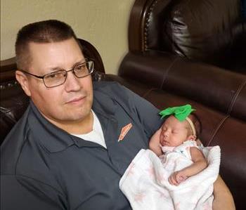 Paul Frost holding one the of newest Frost family infants.